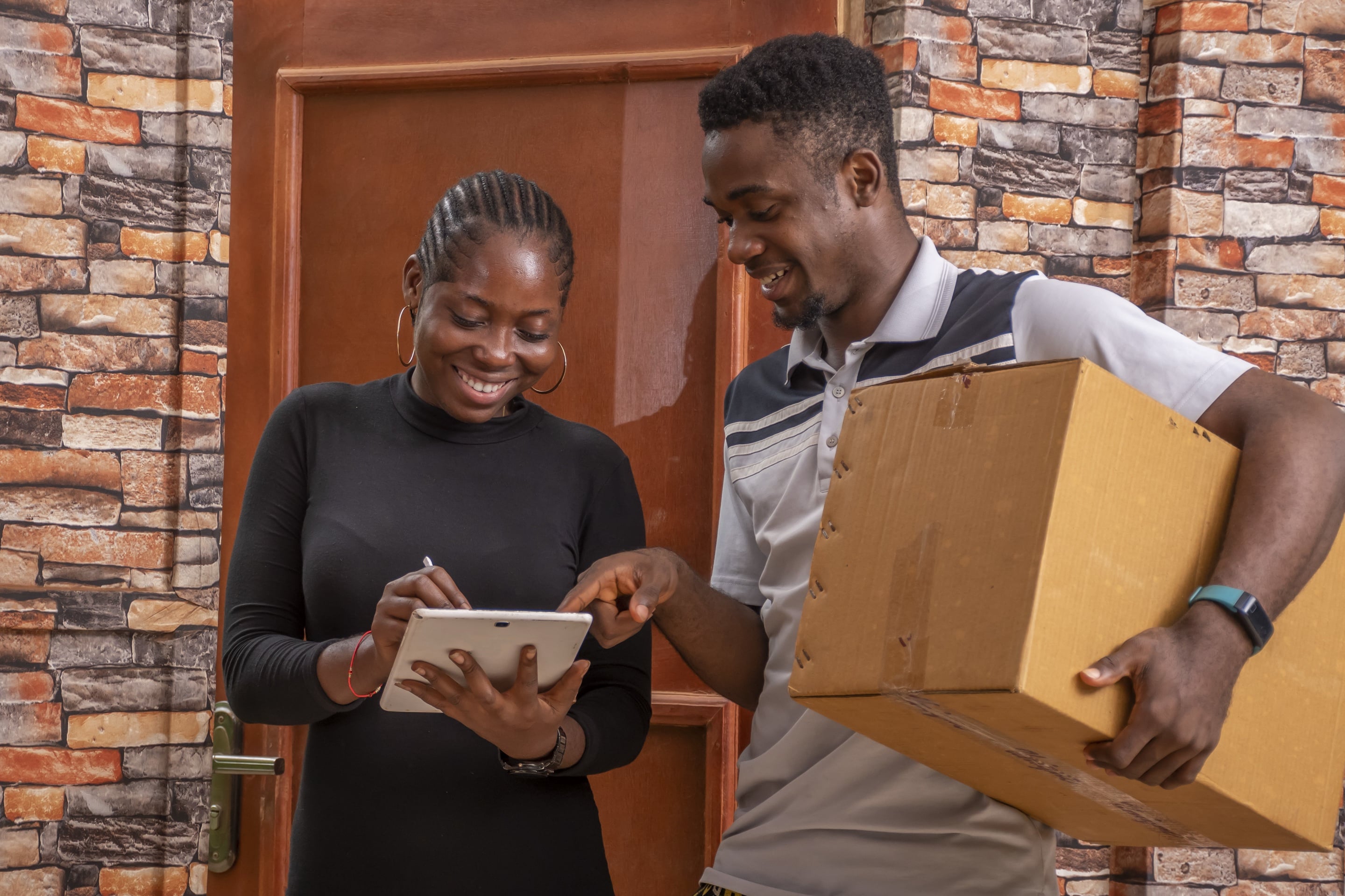 A courier handing a parcel over at a door